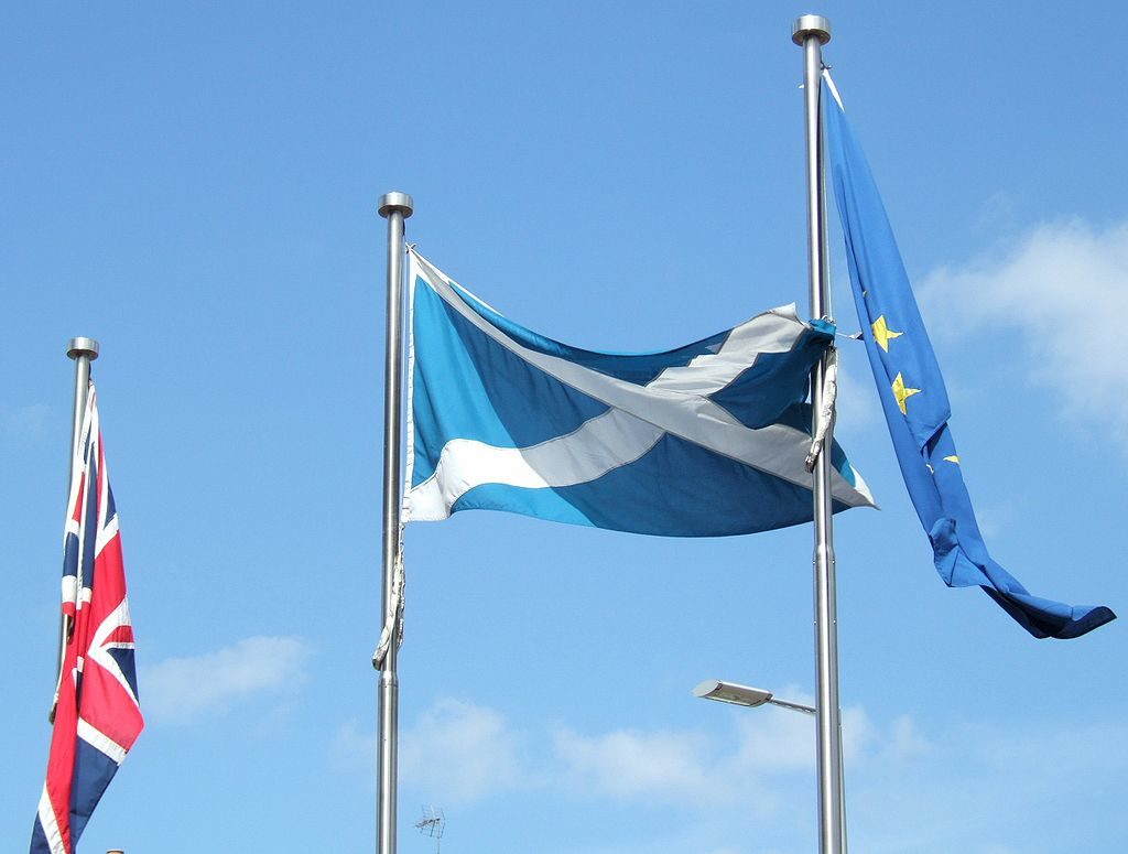 A flag of Scotland flying next to the EU and Union flag