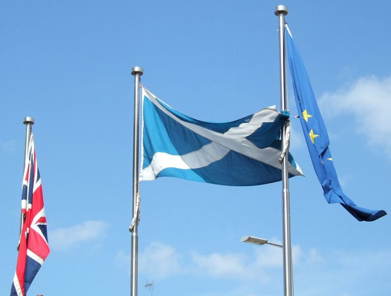 A flag of Scotland flying next to the EU and Union flag