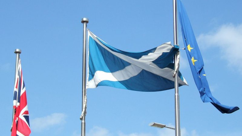 A flag of Scotland flying next to the EU and Union flag