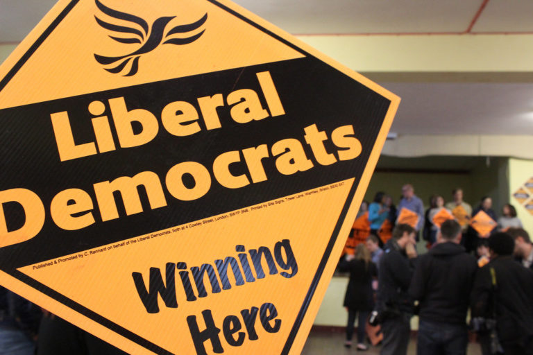 A placard reading "Liberal Democrats winning here"