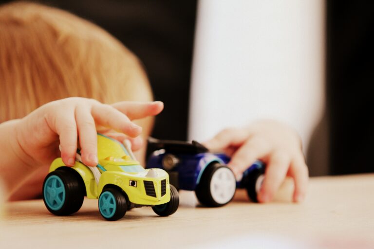 child at table playing with toy cars - Photo by Sandy Millar on Unsplash