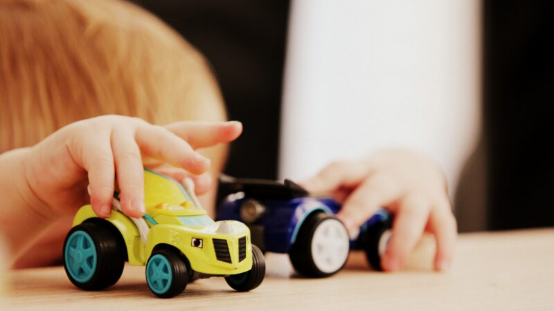 child at table playing with toy cars - Photo by Sandy Millar on Unsplash