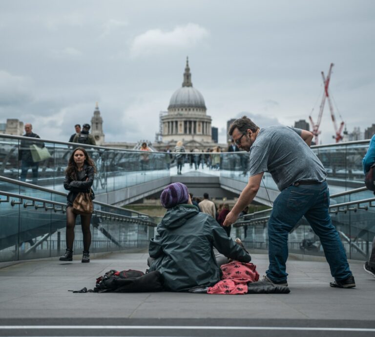 Man helps homeless person by London's Millenium Bridge - Photo by Tom Parsons on Unsplash