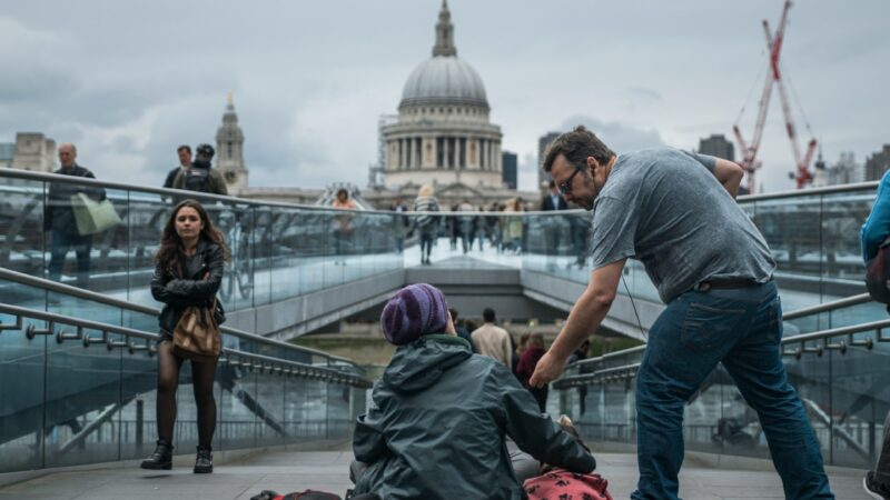 Man helps homeless person by London's Millenium Bridge - Photo by Tom Parsons on Unsplash