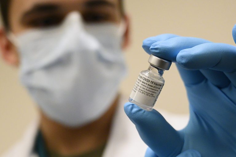 Man with mask holding vaccine