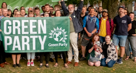 Green Party activists standing with a party banner