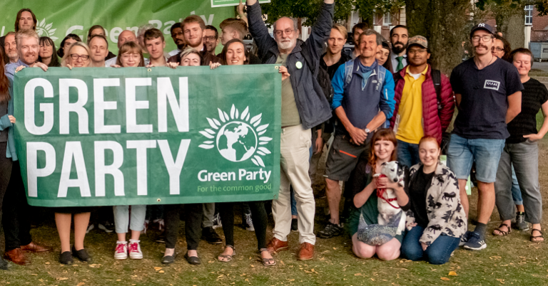 Green Party activists standing with a party banner
