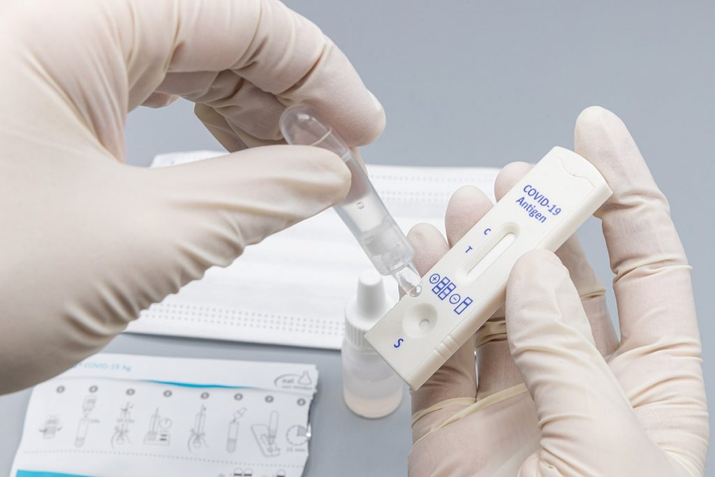 A person's hands running a Covid test