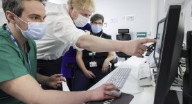 A photo of Boris Johnson pointing at a computer screen