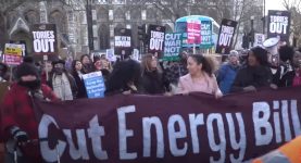 A protest with campaigners holding a banner reading "cut energy bills"