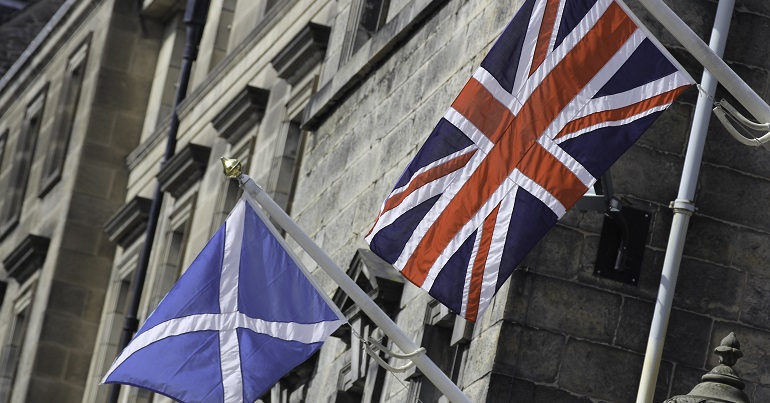 A photo of a saltire next to a union flag flown from the side of a building