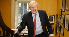 Boris Johnson walking up a set of stairs smiling