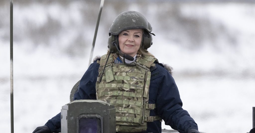 Liz Truss in military wear sat on a tank