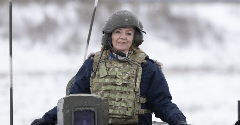 Liz Truss in military wear sat on a tank