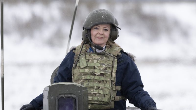 Liz Truss in military wear sat on a tank