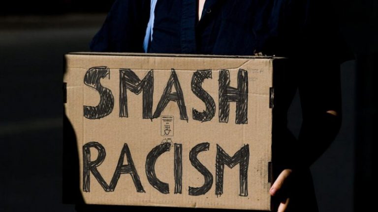 A placard reading smash racism