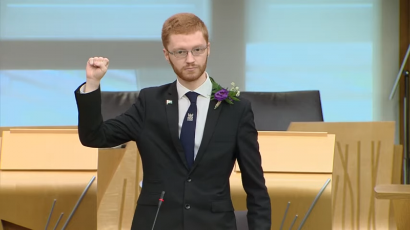Ross Greer raising a fist at his oath in the Scottish Parliament