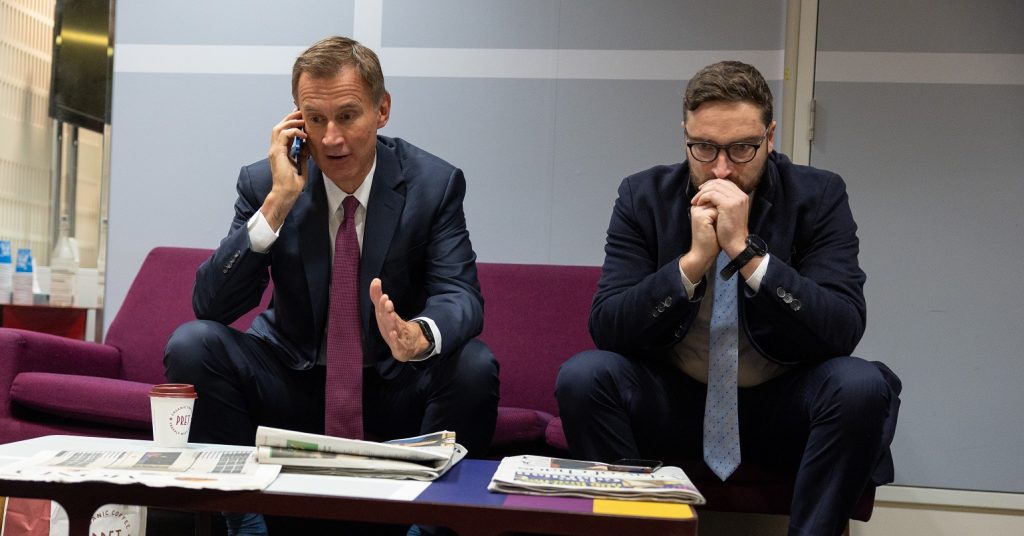 Jeremy Hunt on the phone with an advisor on a sofa next to him