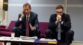 Jeremy Hunt on the phone with an advisor on a sofa next to him