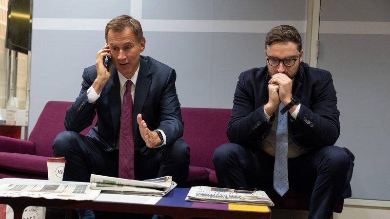 Jeremy Hunt on the phone with an advisor on a sofa next to him