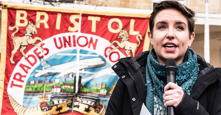Carla Denyer speaking in front of a Bristol Trades Council banner
