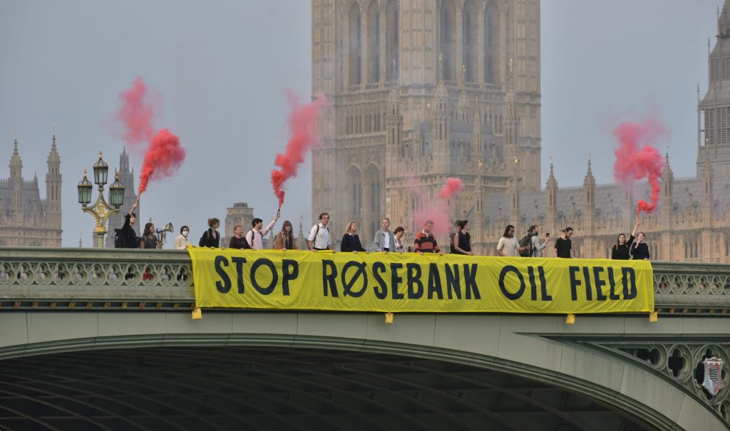 Climate campaigners dropping a banner reading "Stop Rosebank Oil Field" on Westminster Bridge