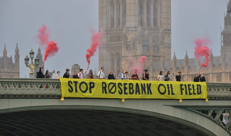 Climate campaigners dropping a banner reading "Stop Rosebank Oil Field" on Westminster Bridge
