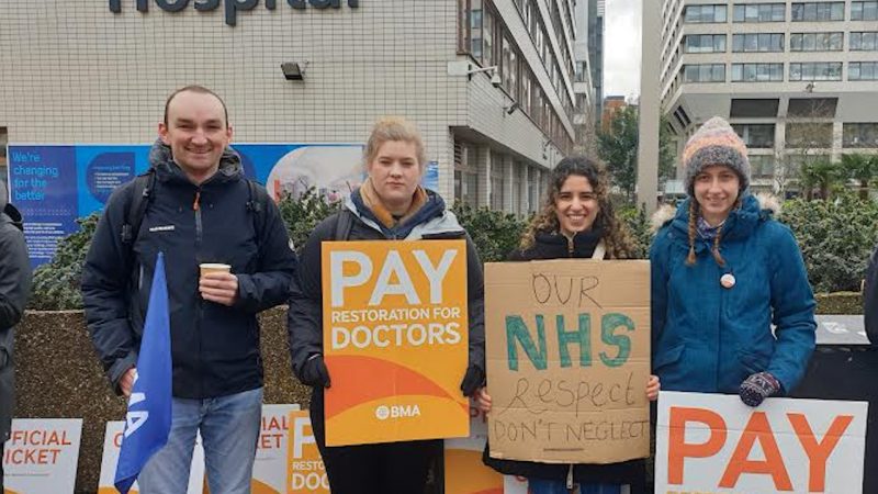A photo of doctors on a picket line striking for higher pay.