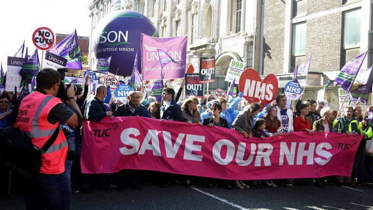 A demonstration led by a banner reading 'Save our NHS'
