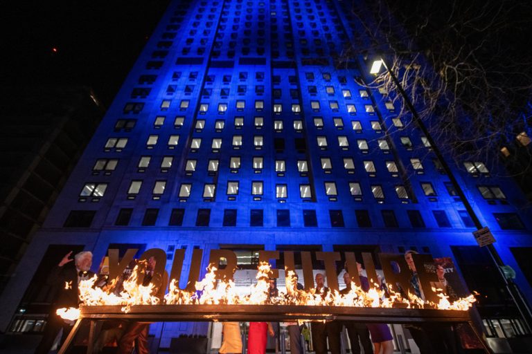 Greenpeace activists disguised as Shell executives drink champagne and dance around a burning sign reading ‘Your Future’ at a mock party outside the Shell headquarters as the company made its profit announcement in 2023.