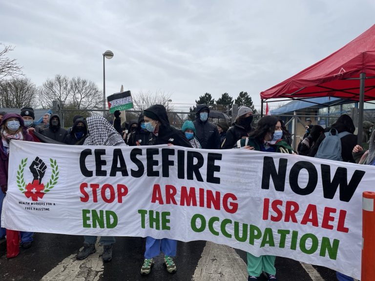 Trade unionist arms factory protest Israel. Banner at front of protest reads "ceasefire now, stop arming Israel, end the occupation'