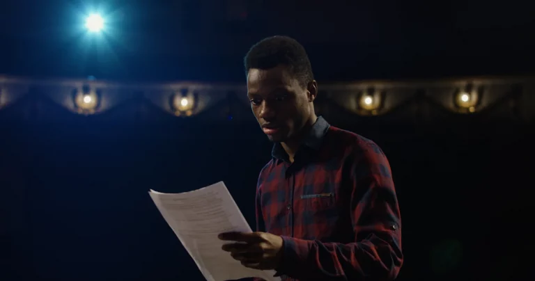 A photo of a male actor reading a script