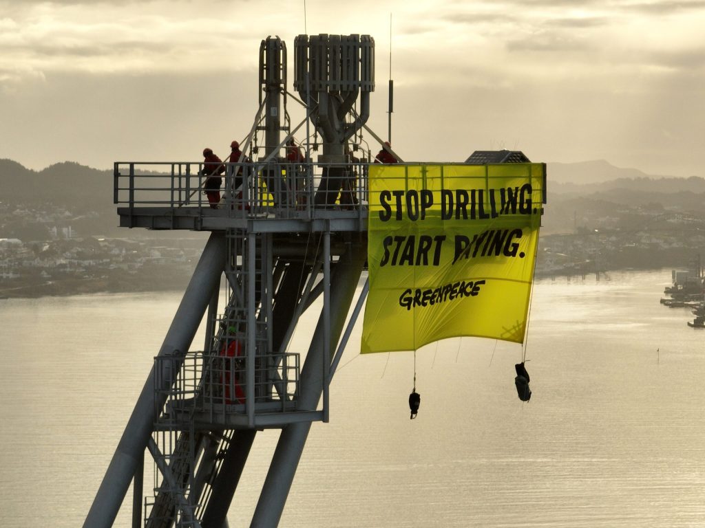 A photo of a Greenpeace banner hanging from a platform on one of Shell's oil vessels.