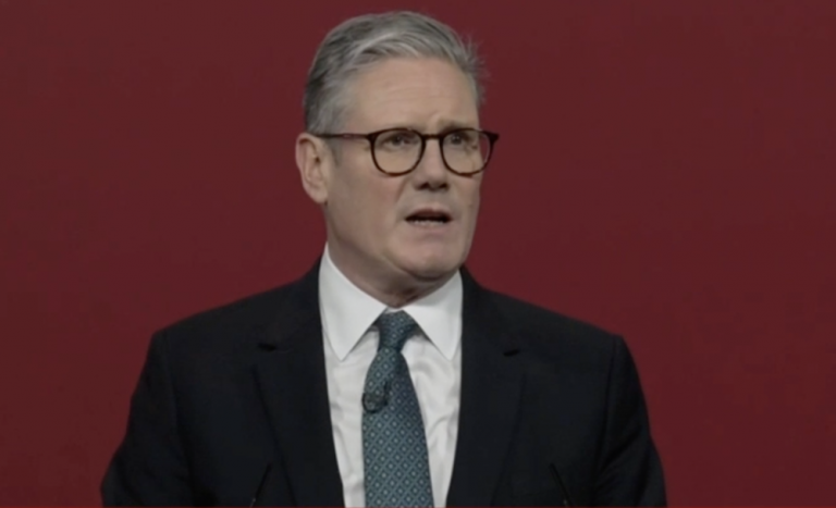 A photo of Keir Starmer making a speech at a lectern.