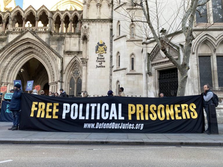 A photo of people protesting against climate activists' long jail sentences outside the Royal Courts of Justice