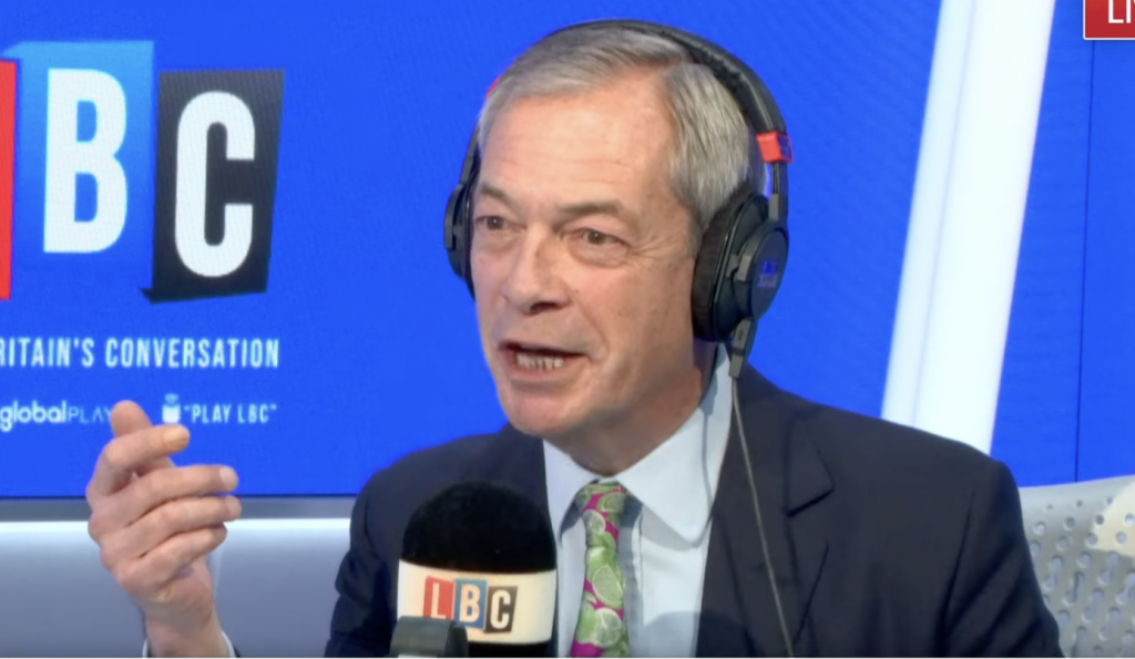 A photo of Nigel Farage wearing a headset as he appears on LBC Radio