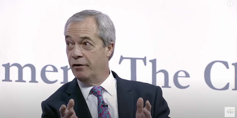 A photo of Nigel Farage speaking at the far-right ARC conference