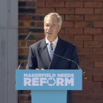 A photo of Nigel Farage responding to journalists' questions
