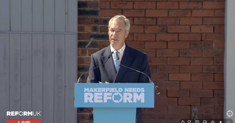 A photo of Nigel Farage responding to journalists' questions