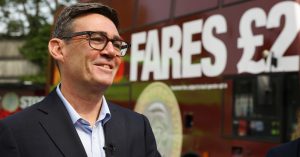 Andy Burnham in front of a bus advertising the £2 bus fare cap