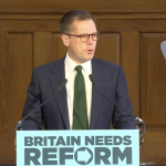 A photo of Robert Jenrick addressing a Reform press conference