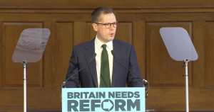 A photo of Robert Jenrick addressing a Reform press conference