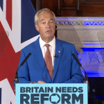 A photo of Nigel Farage speaking at a Reform press conference